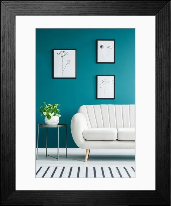 Framed Print : Cropped photo of a white sofa in living room interior with metal table with a plant and paintings on the green wall Framed Print : Cropped photo of a white sofa in living room interior with metal table with a plant and paintings on the green wall