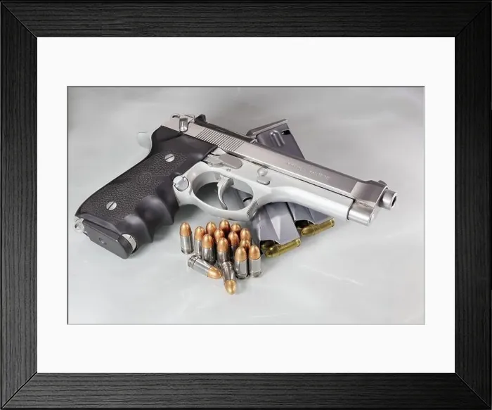 Framed Print : Beretta 92FS or M9 hand gun and pack of bullets 9mm parabellum isolated on reflection surface Framed Print : Beretta 92FS or M9 hand gun and pack of bullets 9mm parabellum isolated on reflection surface