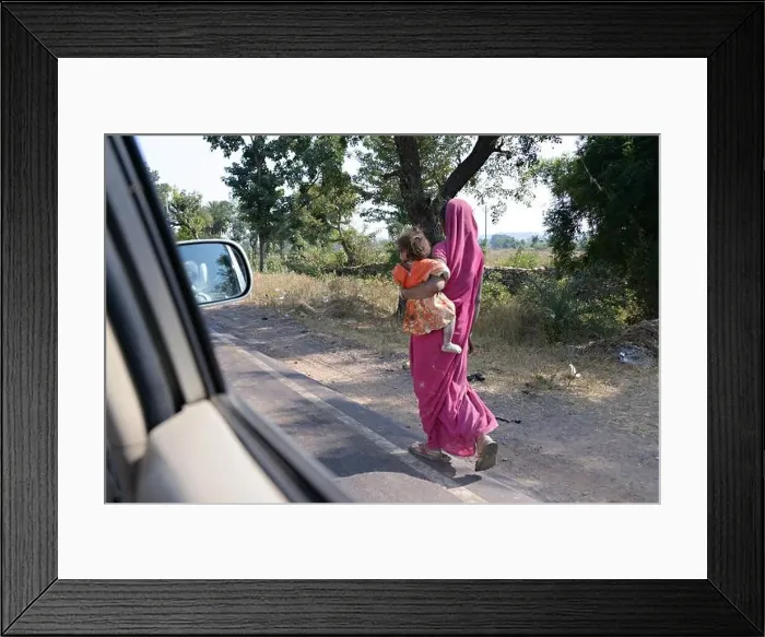 Framed Print : Indian local woman with child, walking at the roadside in india Framed Print : Indian local woman with child, walking at the roadside in india