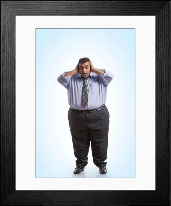 Framed Print : Overweight man in formal clothes holding his head with both hands with an expression of shock Framed Print : Overweight man in formal clothes holding his head with both hands with an expression of shock