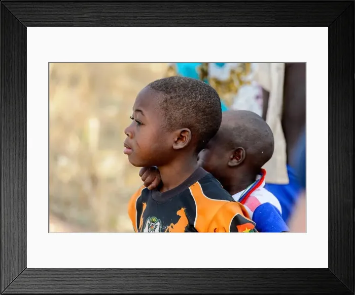 Framed Print : KOUTAMMAKOU, TOGO - JAN 13, 2017: Unidentified Togolese little boy carries his brother on his back in the village Framed Print : KOUTAMMAKOU, TOGO - JAN 13, 2017: Unidentified Togolese little boy carries his brother on his back in the village
