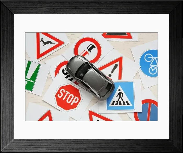 Framed Print : Cards with different road signs and toy car on white wooden table, flat lay. Driving school Framed Print : Cards with different road signs and toy car on white wooden table, flat lay. Driving school