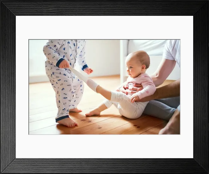 Framed Print : Father and toddler children sitting on the floor at home at bedtime Framed Print : Father and toddler children sitting on the floor at home at bedtime