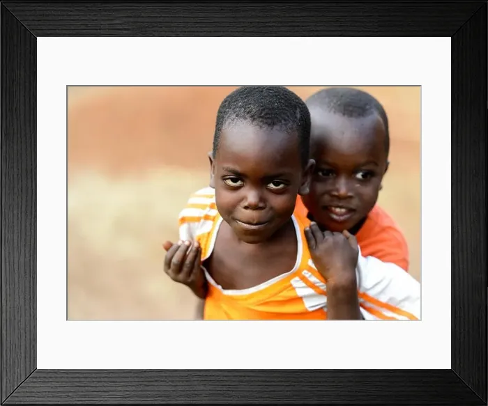 Framed Print : MASSIF KABYE, TOGO - JAN 13, 2017: Unidentified Togolese little boy carries his friend in the village Framed Print : MASSIF KABYE, TOGO - JAN 13, 2017: Unidentified Togolese little boy carries his friend in the village