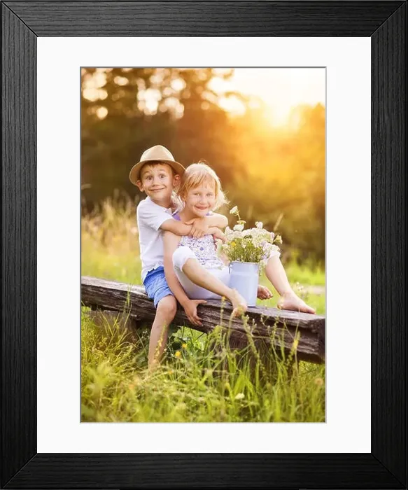 Framed Print : Cute boy and girl in love. They sitting on bench at sunset Framed Print : Cute boy and girl in love. They sitting on bench at sunset