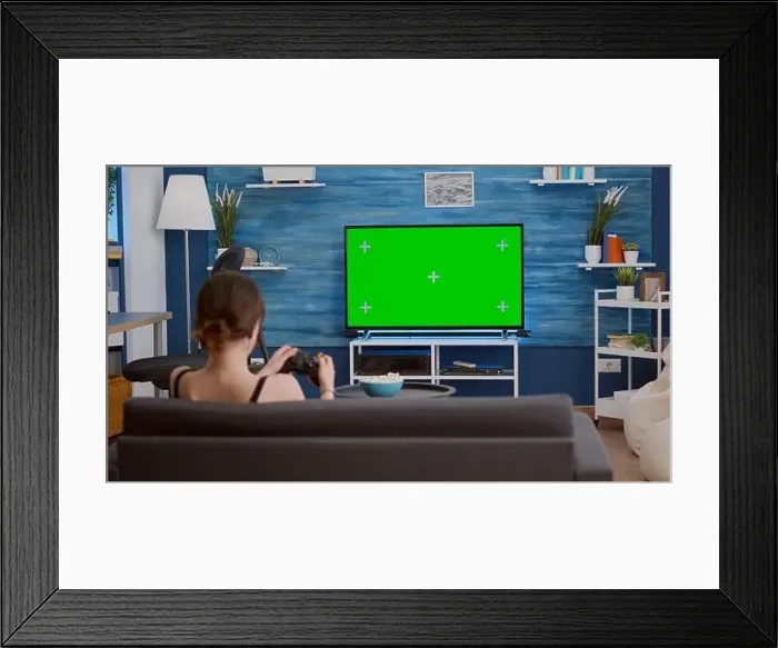 Framed Print : Gamer girl playing console video games with wireless controller on green screen tv relaxing on couch in living room Framed Print : Gamer girl playing console video games with wireless controller on green screen tv relaxing on couch in living room