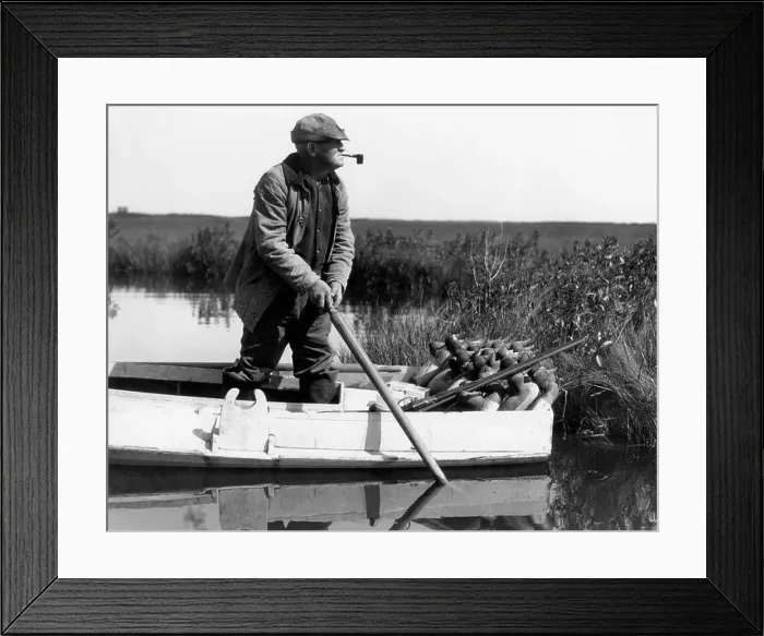Framed Print : 1920s 1930s SENIOR MAN DUCK HUNTER STANDING IN SNEAK-BOX BOAT ABOUT TO DEPLOY DECOYS IN BARNEGAT BAY WETLANDS MARSH NEW Framed Print : 1920s 1930s SENIOR MAN DUCK HUNTER STANDING IN SNEAK-BOX BOAT ABOUT TO DEPLOY DECOYS IN BARNEGAT BAY WETLANDS MARSH NEW