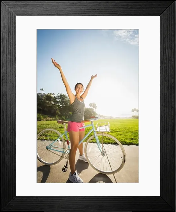 Framed Print : Young woman with bicycle in park Framed Print : Young woman with bicycle in park