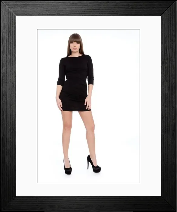 Framed Print : Young woman posing confidently in a short black dress with high heels Framed Print : Young woman posing confidently in a short black dress with high heels