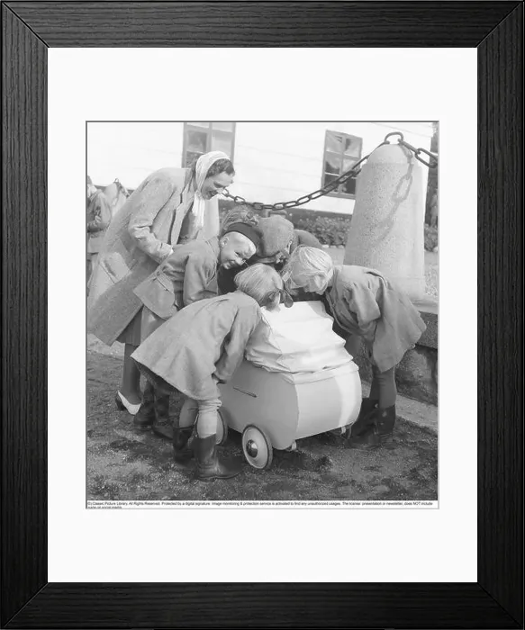 Framed Print : Mother in the 1940s. A young mother is seen with her baby in the carriage Framed Print : Mother in the 1940s. A young mother is seen with her baby in the carriage