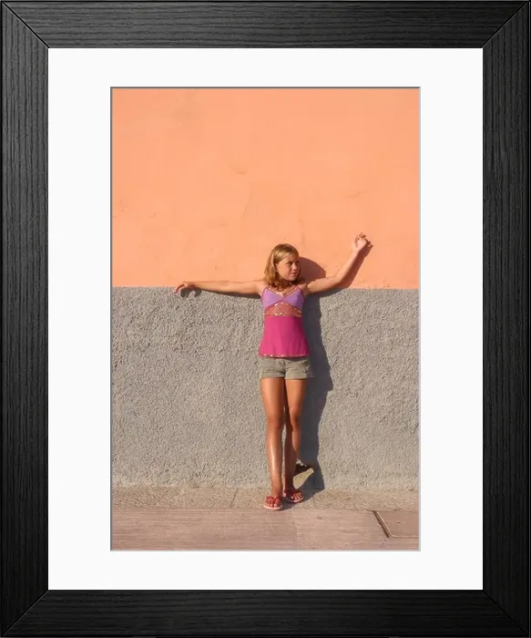 Framed Print : Young girl wearing decorative fashion top and denim shorts on peach background Framed Print : Young girl wearing decorative fashion top and denim shorts on peach background