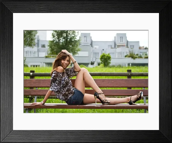 Framed Print : Young woman wearing hot pants, a leopard-print top and high heels, posing on a bench Framed Print : Young woman wearing hot pants, a leopard-print top and high heels, posing on a bench