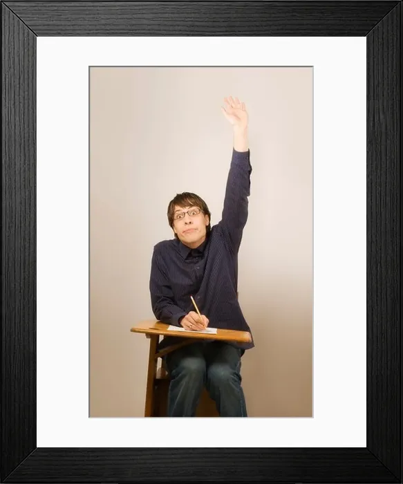 Framed Print : Man raising hand sitting in school desk Framed Print : Man raising hand sitting in school desk