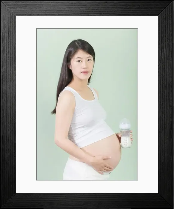Framed Print : young pretty chinese pregnant woman holds her belly Framed Print : young pretty chinese pregnant woman holds her belly