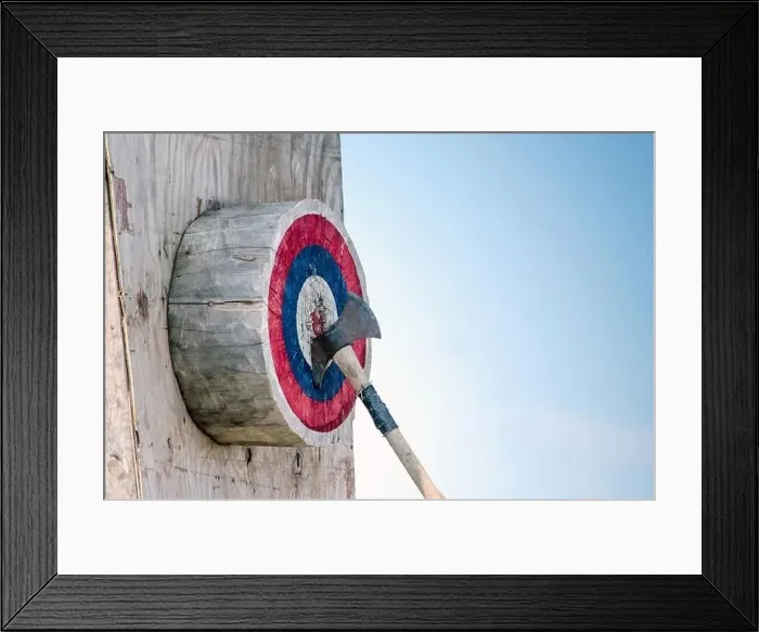 Framed Print : An ax in the center of this wooden bulls-eye shows the person has hit his mark Framed Print : An ax in the center of this wooden bulls-eye shows the person has hit his mark