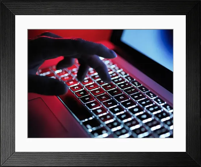 Framed Print : A dark mystery hand typing on a laptop computer at night Framed Print : A dark mystery hand typing on a laptop computer at night