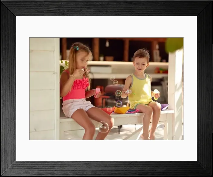Framed Print : cute little girl teaching her brother how to make soap bubbles Framed Print : cute little girl teaching her brother how to make soap bubbles