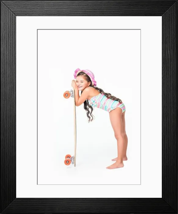 Framed Print : adorable little girl in swimsuit leaning at skateboard isolated on white Framed Print : adorable little girl in swimsuit leaning at skateboard isolated on white