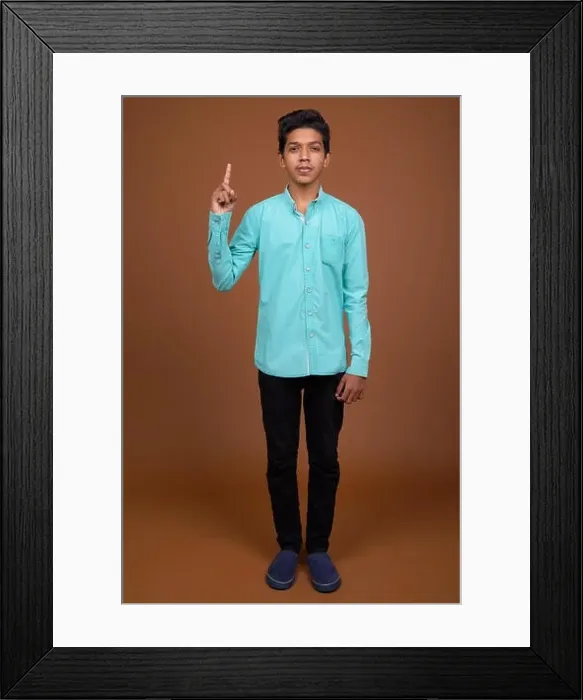 Framed Print : Young Indian boy wearing blue shirt looking smart against brown Framed Print : Young Indian boy wearing blue shirt looking smart against brown