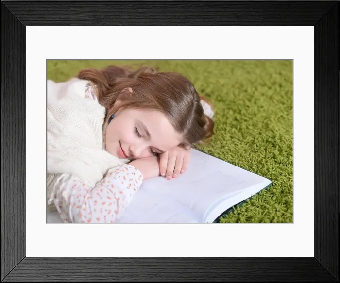 Framed Print : Portrait of a cute little girl lying on green carpet Framed Print : Portrait of a cute little girl lying on green carpet