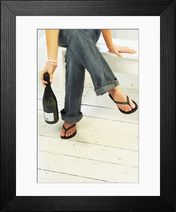 Framed Print : Young womans legs and feet with Champagne Bottle Framed Print : Young womans legs and feet with Champagne Bottle