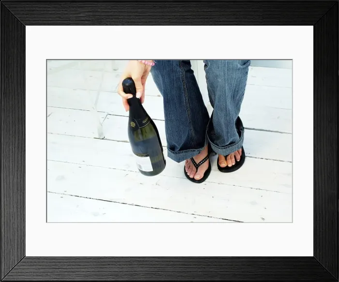 Framed Print : Young womans legs and feet with Champagne Bottle Framed Print : Young womans legs and feet with Champagne Bottle