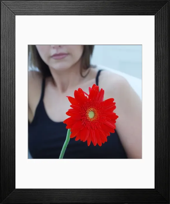 Framed Print : Defocused attractive woman holding a gerbera Framed Print : Defocused attractive woman holding a gerbera