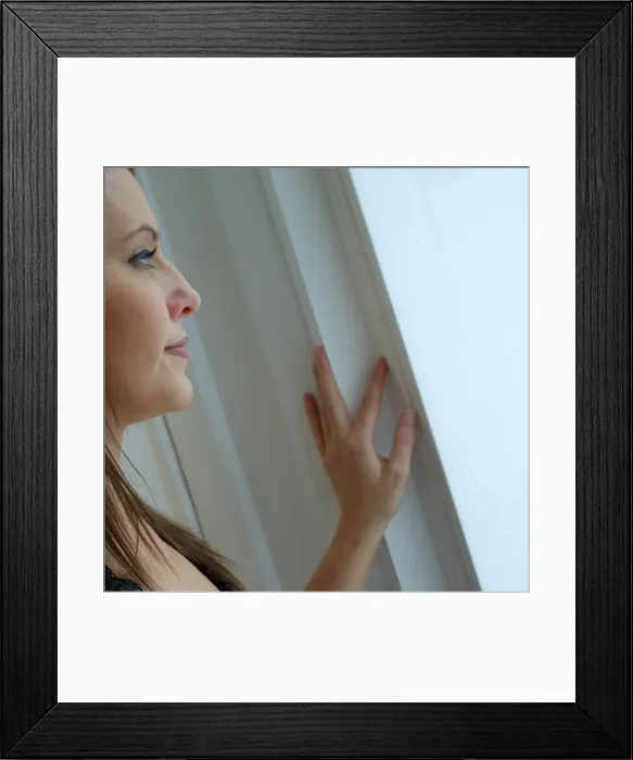 Framed Print : Young woman in evening wear smiling stood at window Framed Print : Young woman in evening wear smiling stood at window