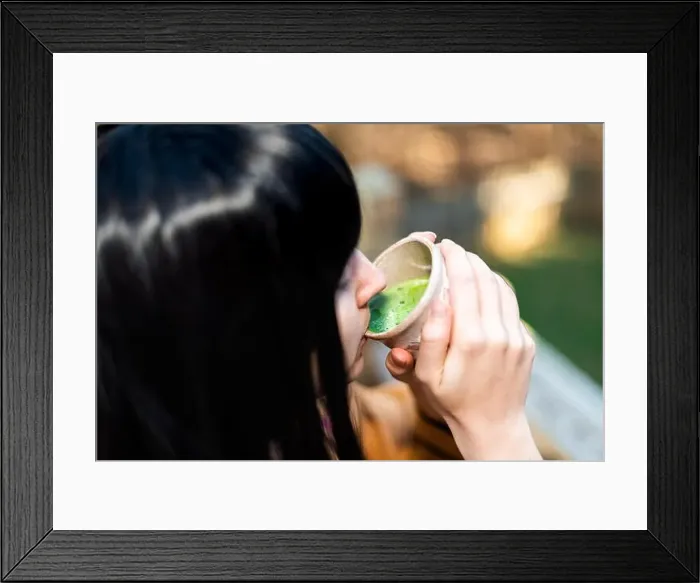 Framed Print : Woman holding tea cup face closeup drinking outside in backyard garden with girl and green matcha black hair Framed Print : Woman holding tea cup face closeup drinking outside in backyard garden with girl and green matcha black hair