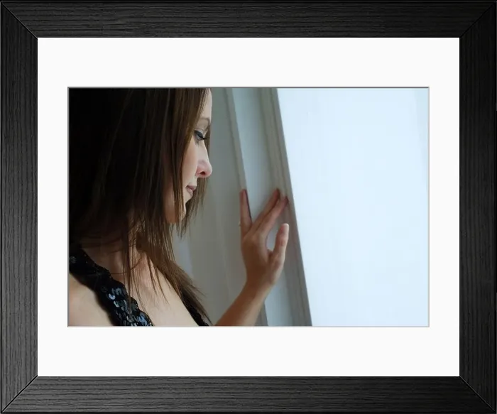 Framed Print : Young woman looking our of window Framed Print : Young woman looking our of window