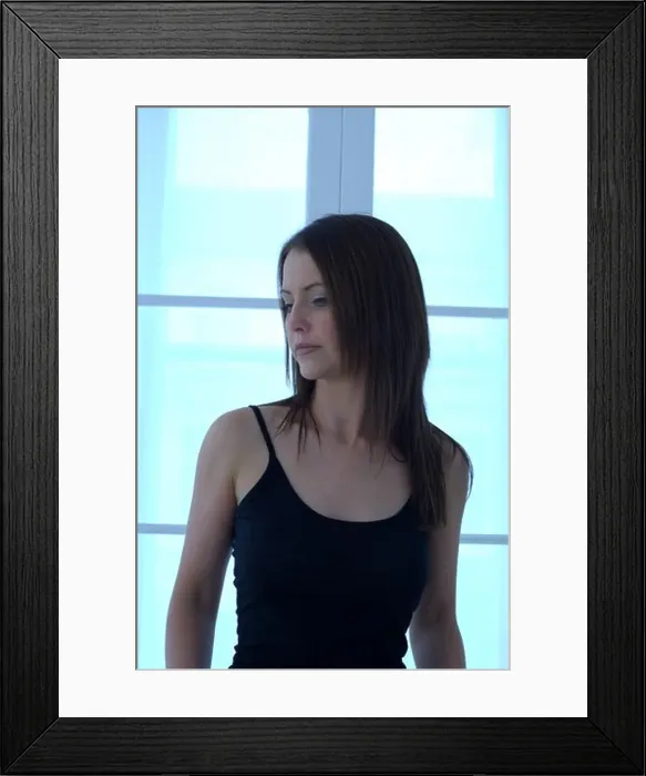 Framed Print : Young woman in front of a window looking pensive Framed Print : Young woman in front of a window looking pensive