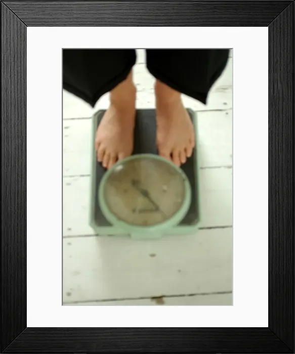 Framed Print : Old Fashioned Weighing scales and feet defocused Framed Print : Old Fashioned Weighing scales and feet defocused