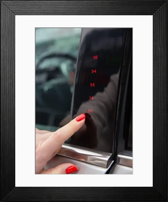 Framed Print : A woman's hand enters the secret code for opening the car door on the touch panel Framed Print : A woman's hand enters the secret code for opening the car door on the touch panel