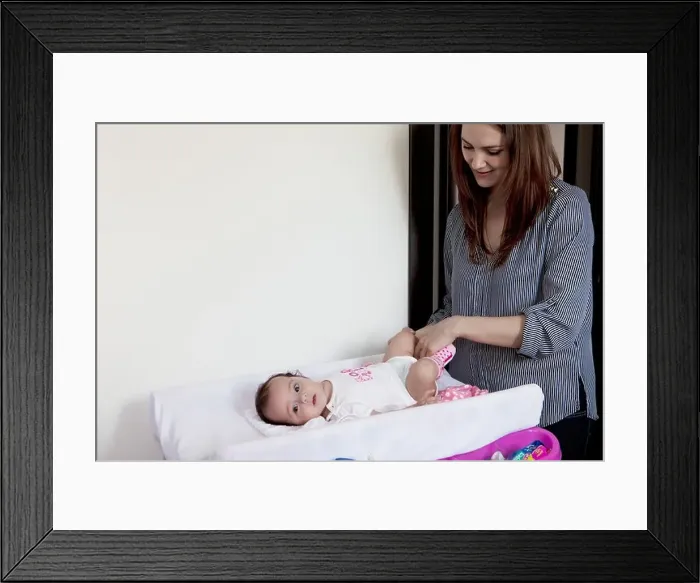 Framed Print : baby girl on the changing table, diaper change Framed Print : baby girl on the changing table, diaper change