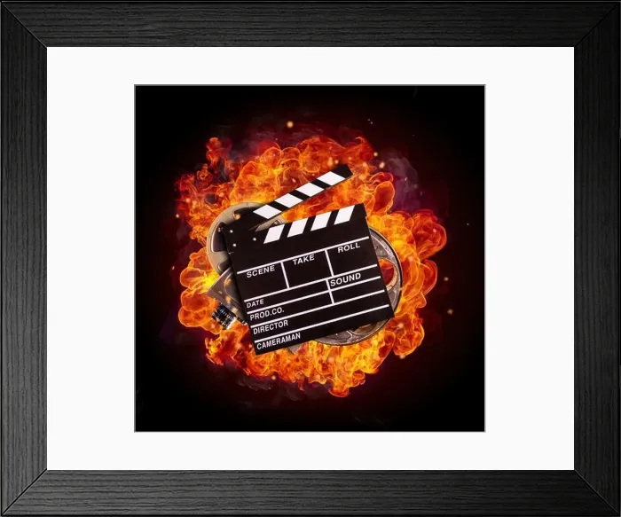 Framed Print : Film clapper, reel and camera in fire, isolated on black background. Concept of filmmaking Framed Print : Film clapper, reel and camera in fire, isolated on black background. Concept of filmmaking