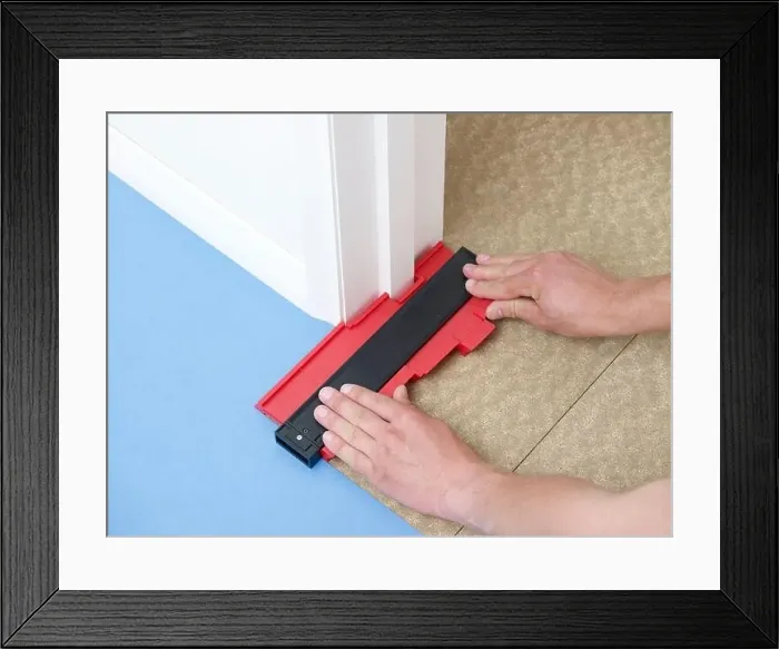 Framed Print : Laying vinyl tile floor, cutting around a corner Framed Print : Laying vinyl tile floor, cutting around a corner
