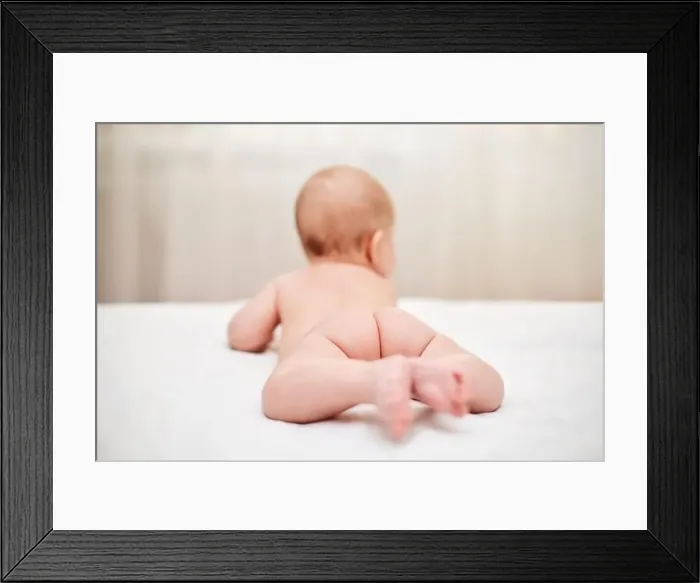 Framed Print : Cute little baby in diaper on bed Framed Print : Cute little baby in diaper on bed