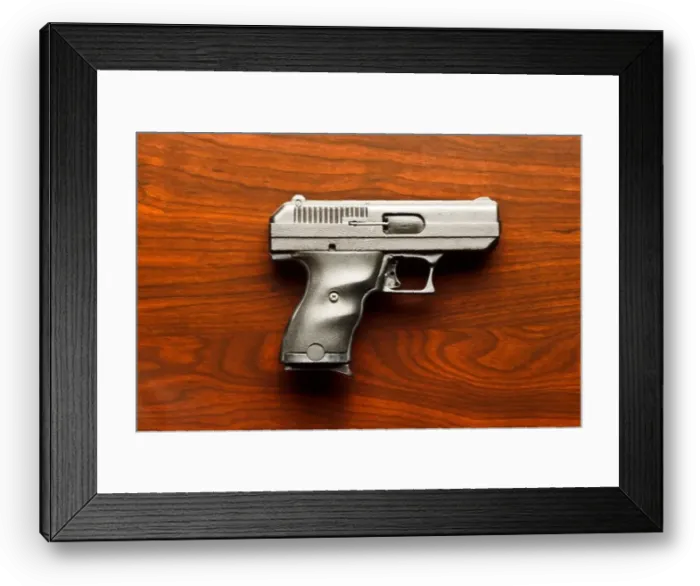 Framed Print : Top view of 9 mm handgun against wooden surface Framed Print : Top view of 9 mm handgun against wooden surface