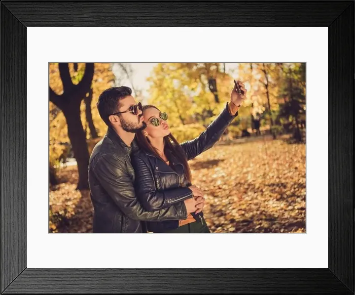Framed Print : Photo of two people, students girl guy hug make selfie on smartphone send air kiss in fall september park wear jacket
