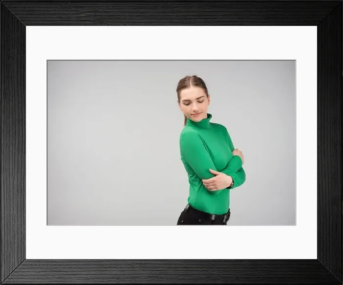 Framed Print : Young girl hugging herself posing in the studio and looking down Framed Print : Young girl hugging herself posing in the studio and looking down