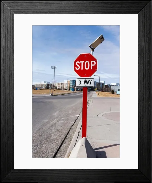 Framed Print : Three-way solar-powered traffic stop sign in a residential neighborhood with tiny light bulbs around the sign that Framed Print : Three-way solar-powered traffic stop sign in a residential neighborhood with tiny light bulbs around the sign that