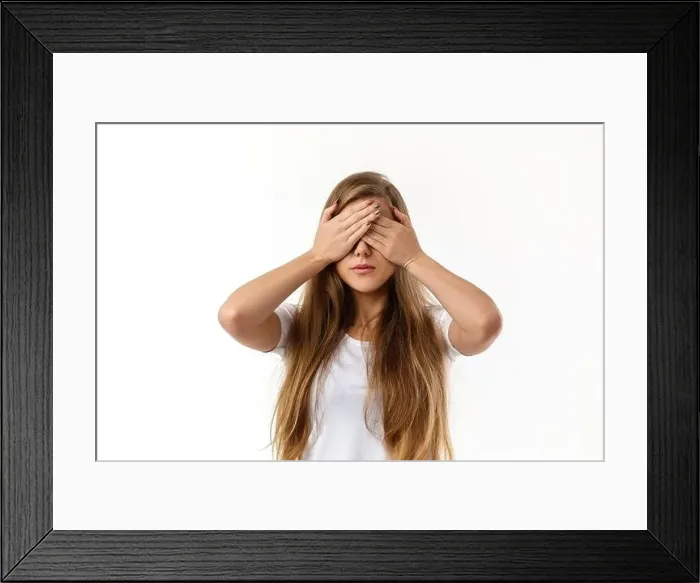 Framed Print : Portrait of young beautiful woman closes her eyes with hand on white background