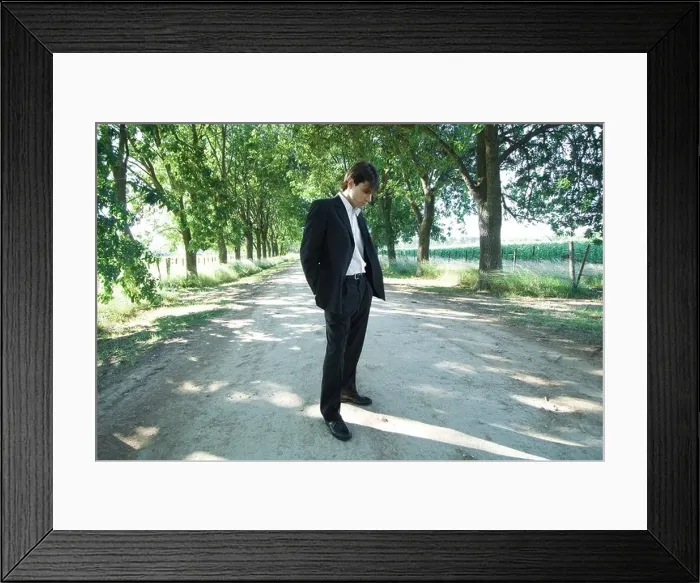 Framed Print : Businessman standing in rural road, looking down