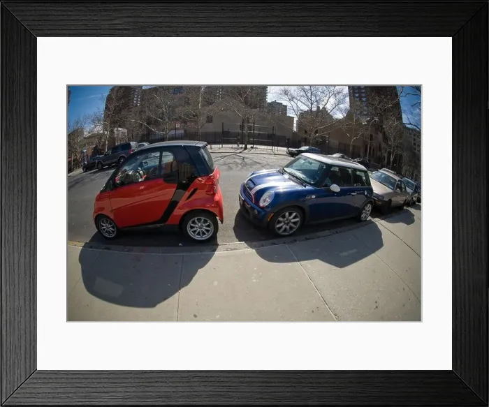 Framed Print : A two-seat Smart car, left, manufactured by Daimler and a Mini Cooper are seen squeezed into a parking spot in New York Framed Print : A two-seat Smart car, left, manufactured by Daimler and a Mini Cooper are seen squeezed into a parking spot in New York