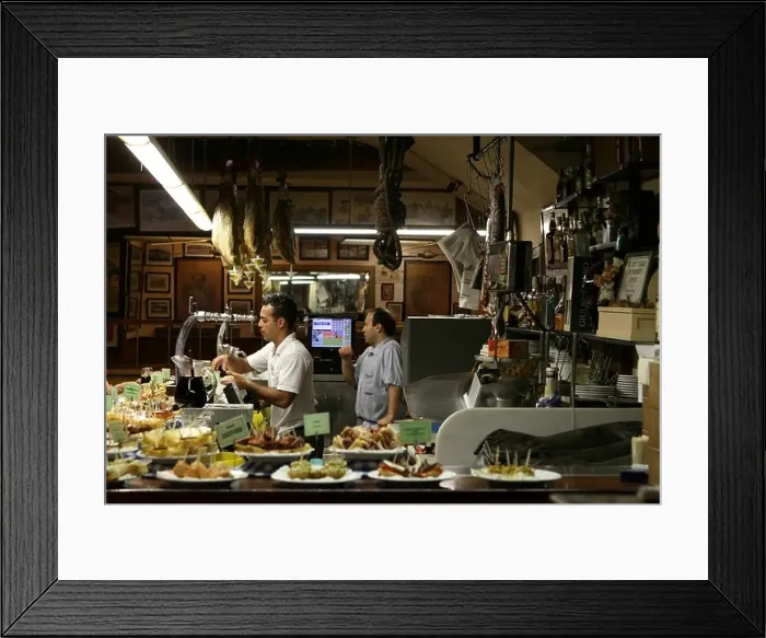 Framed Print : Two men selling pintxos inside a tapas bar in San Sebastian, Basque Country, Northern Spain, Europe