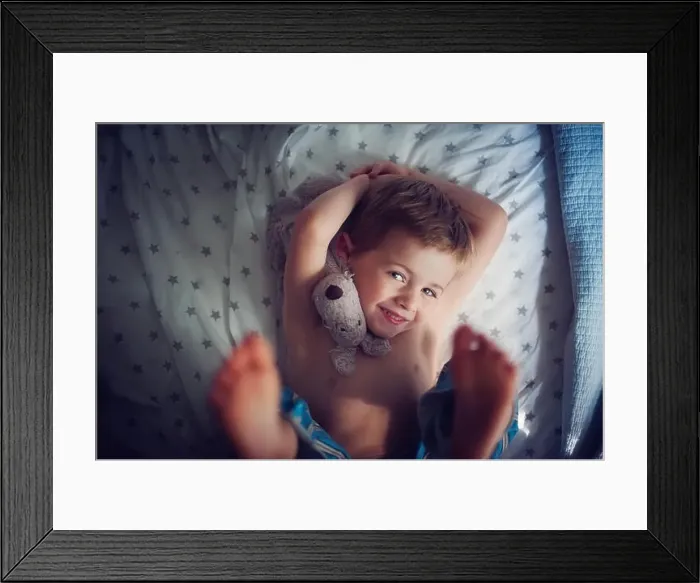 Framed Print : Smiling Boy lying on bed with cuddly toy Framed Print : Smiling Boy lying on bed with cuddly toy