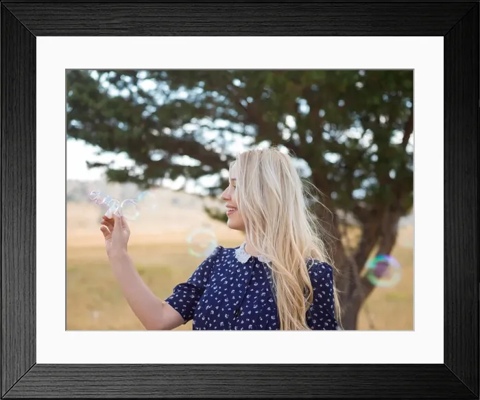 Framed Print : Portrait of a beautiful young woman blowing soap bubbles in the park on a sunny summer day Framed Print : Portrait of a beautiful young woman blowing soap bubbles in the park on a sunny summer day