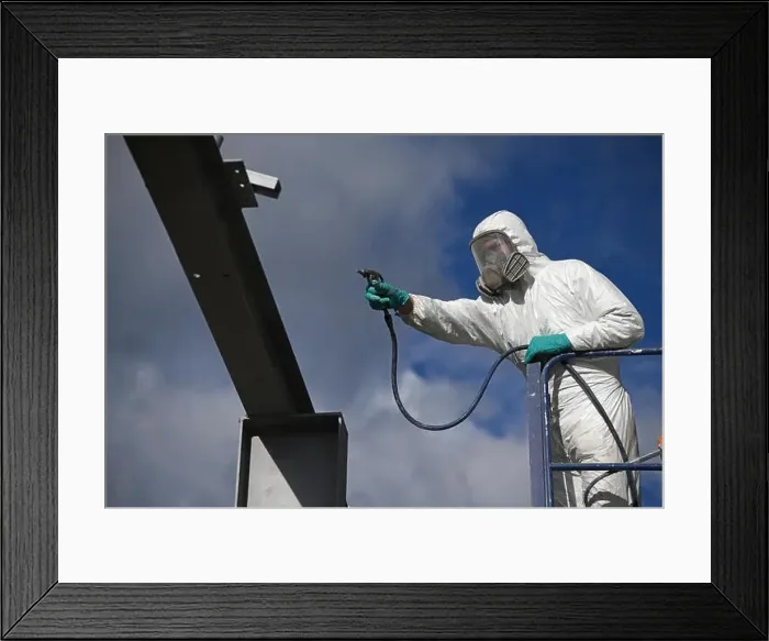 Framed Print : Tradesman spray paints the steel beams on a construction site Framed Print : Tradesman spray paints the steel beams on a construction site
