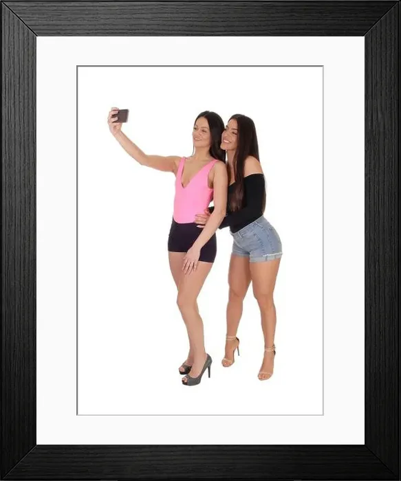 Framed Print : Two happy young slim women standing in the studio in shorts and high heels Framed Print : Two happy young slim women standing in the studio in shorts and high heels