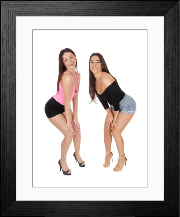 Framed Print : A two happy young slim women standing in the studio in shorts and high heels Framed Print : A two happy young slim women standing in the studio in shorts and high heels